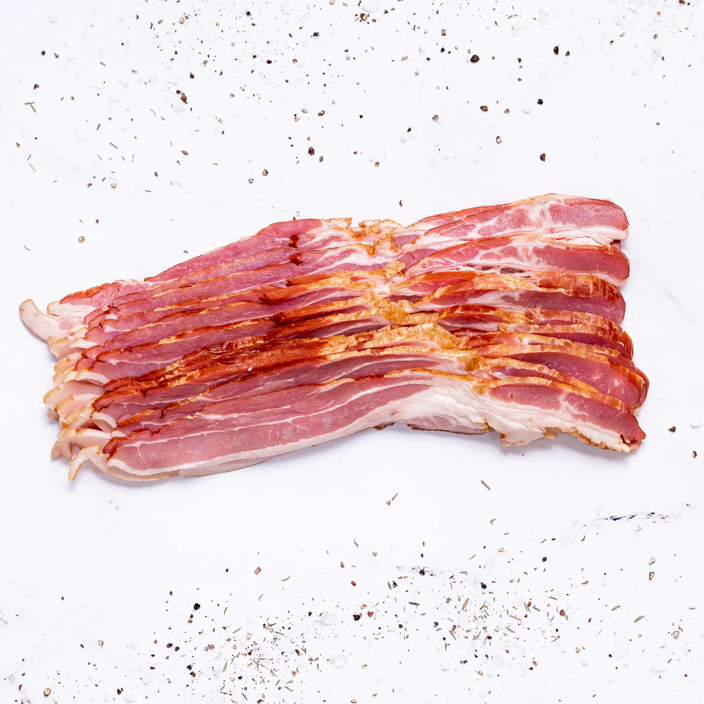 Two FREE Packs of Applewood Bacon are displayed on a white surface, sprinkled with black pepper and seasoning.